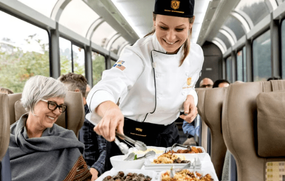 Rocky Mountaineer chef serving gourmet dining onboard