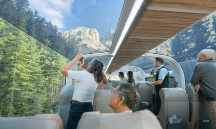 View through the Rocky Mountaineer glass dome roof showing mountain forest